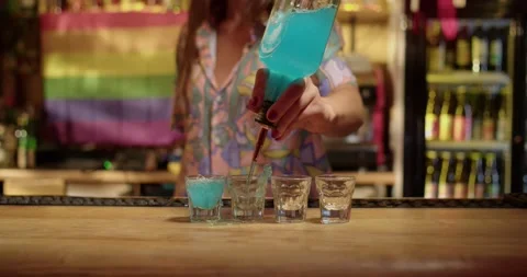 Bartender serving shots of blue liquor Stock Footage 203900896