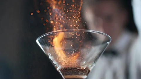 Bartender sets fire to cocktail burning cinnamon in alcohol drink Stock Footage 143589051