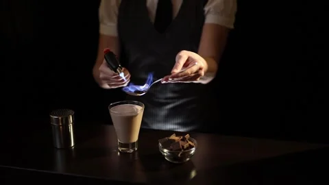 Bartender setting Baileys comet cocktail on fire Stock Footage 133433094