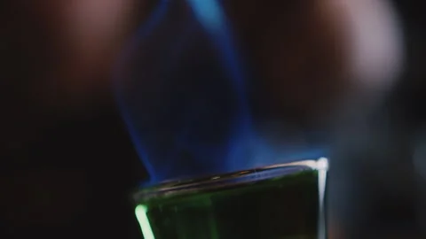 Bartender setting fire to an alcoholic cocktail in a shot glass Stock Footage 252608441
