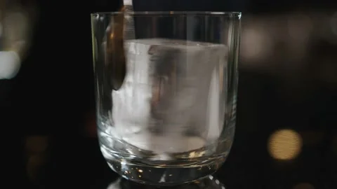 The bartender shakes an ice cube in a glass Stock Footage 167888996