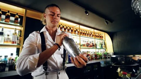 Bartender shaking cocktail creating drinks in bar Stock Photos