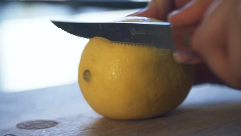 Bartender slicing lemon with serrated knife before cocktail serving Stock Footage 87267075