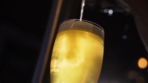 Bartender slowly pours beer into transparent glass Video stock 153974253