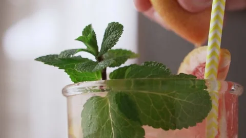 Bartender squeezes the juice from a wedge of grapefruit into a cocktail. Stock Footage 146373422