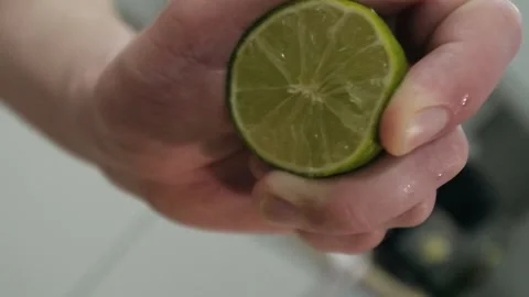 The bartender squeezes the lime in his hand. Lime juice is poured into a shaker Stock Footage 130322377