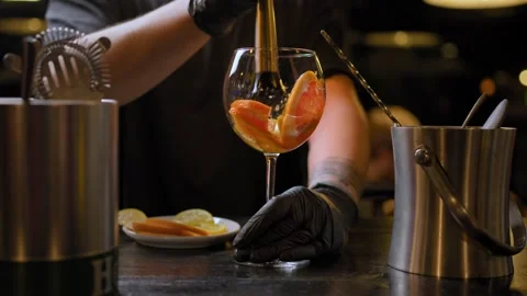 The bartender squeezing a citrus fruit into a glass on the Bar counter Stock Footage 274819493