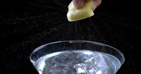 Bartender squeezing lemon while preparing alcoholic cocktail with ice cubes Stock Footage 269381165