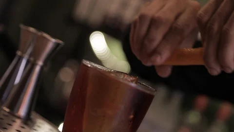 Bartender Squeezing Orange Peel on Negroni Cocktail Stock Footage 129780910