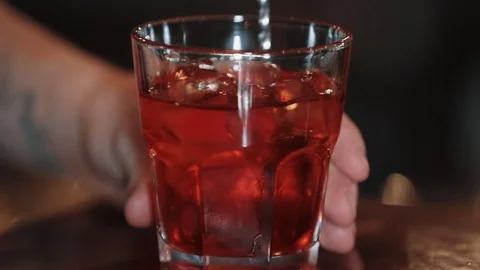 Bartender stirring an alcoholic beverage with ice in the glass. Man's hand Video stock 129110883