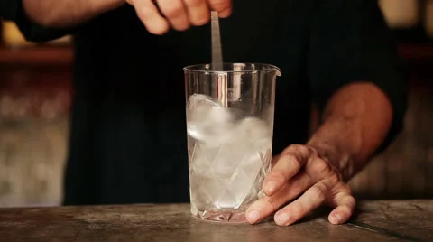 Bartender stirring ice cubes in glass Stock Footage 63297749
