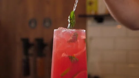Bartender stirs fresh strawberry lemonade with berry syrup with a long spoon. Stock Footage 345131843