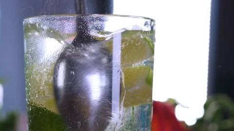 Bartender stirs lime slices in a classic mojito cocktail in glass. Stock-Footage 120431205