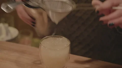 Bartender Strains and Pours Cocktail Over Ice at Bar Counter in Beijing, China Stock Footage 345748248