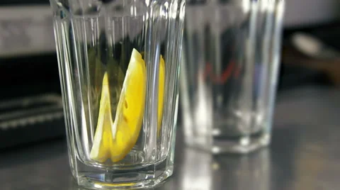 Bartender strewing lemon, mint and lots of ice into glasses Stock Footage 41777943