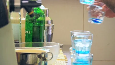 Bartender is taking glasses of blue drink Stock Footage 77476347