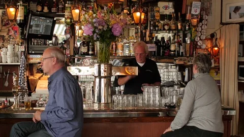Bartender tapping beer in typical old Amsterdam café Stock Footage 76697150