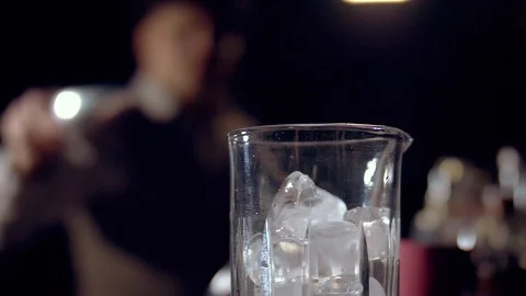 The bartender throws an ice cube into a mixing glass. Slow motion. Video stock 124241272