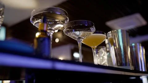 The bartender throws ice into several glasses, close-up. Adding ice to the .. Stock Photos