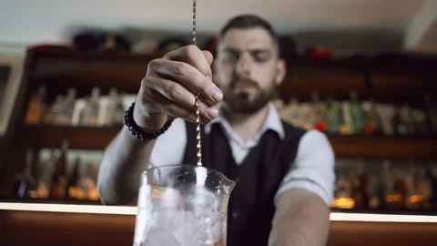 Bartender uses a long bar spoon to stir a cocktail Video stock 157927255