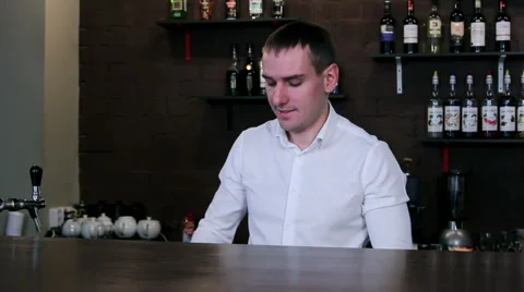 Bartender at work behind the bar and offer beer bottel Stock Footage 58033899