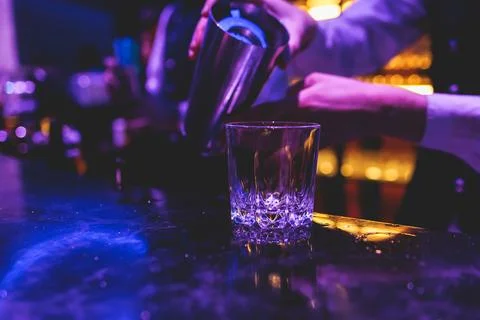 Bartender working, beautiful row line of different coloured liquor alcohol .. Stock Photos