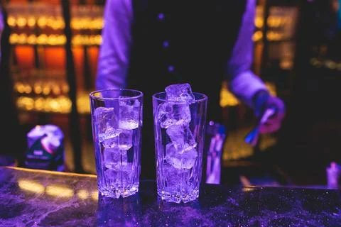 Bartender working, beautiful row line of different coloured liquor alcohol .. Stock Photos