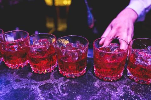 Bartender working, beautiful row line of different coloured liquor alcohol .. Stock Photos