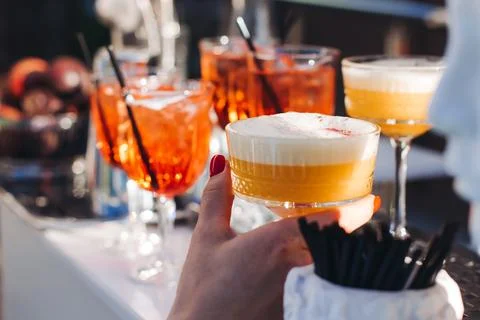 Bartender working, beautiful row line of different coloured liquor alcohol .. Stock Photos
