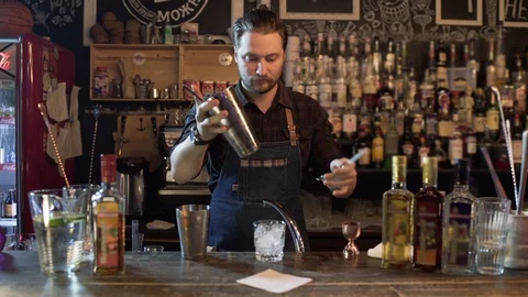 Bartender working in pub mixing ingredients in shaker for making cocktails 스톡 동영상 96241598