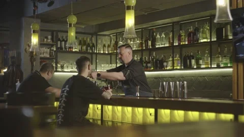 A bartender works at a bar serving people. Stock Footage 232982247