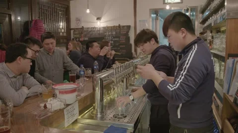 Bartenders Pouring and Serving Drinks at Busy Bar Counter in Beijing, China Stock Footage 345750995