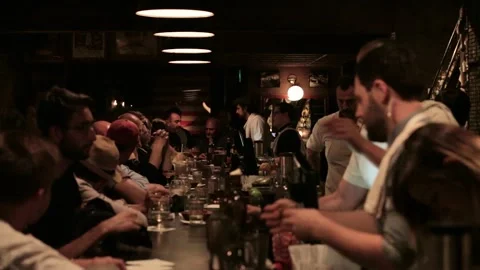 Bartenders Serve Drinks to Customers at a Lively Bar Counter in Sydney Stock Footage 345691150