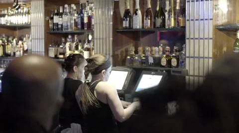 Bartenders using computer behind bar at club slow motion NYC 스톡 동영상 50064119