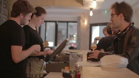 Bartenders Using Register While Customer Waits Drinking Beer Stock Footage 344683464