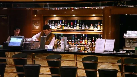 Bartenders work at the bar with bottles at background of a cruise ship Stock Footage 71815073