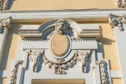 Bas-relief in the form of a muzzle of a lion above the window of an old build Stock Photos