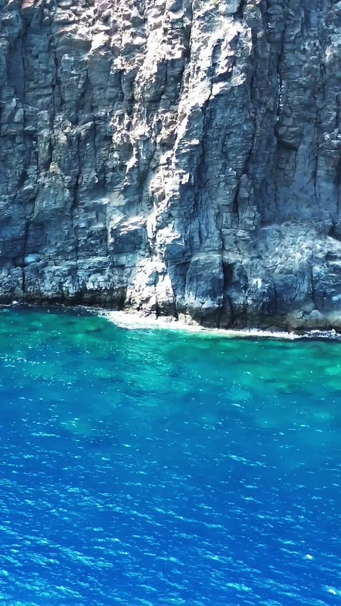 Basalt cliff meeting the turquoise atlantic ocean in Tenerife Stock Footage 319943495