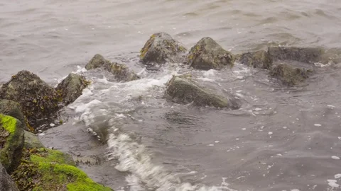 Basalt quarrystone sea dike at high tide Stock Footage