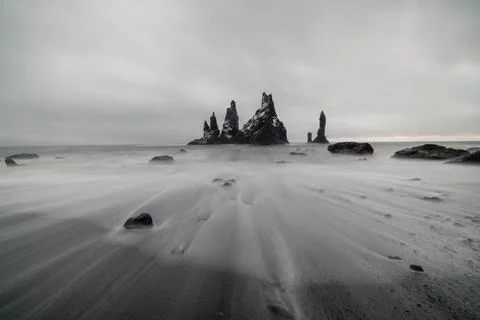 Basalt rock formations Troll toes on black beach. at storm Reynisdrangar, Vik Stock Photos