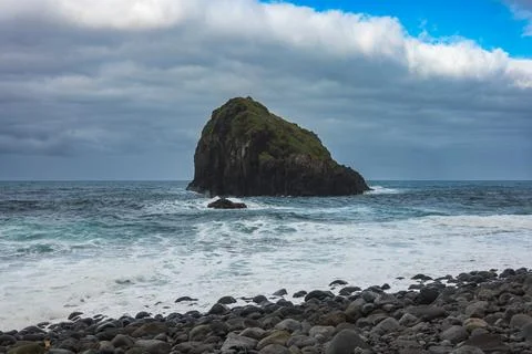Basalt sea stack off Madeira north shore from rocky pebble beach Stock Photos