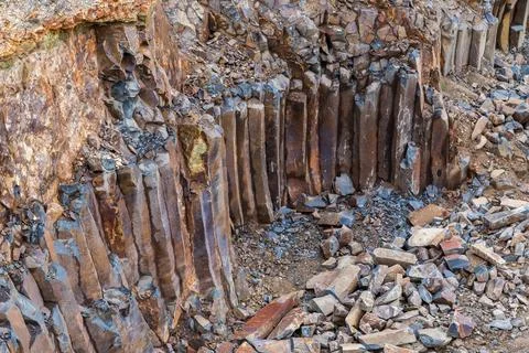 Basaltic columns in wall of basalt quarry in overcast day Foto stock