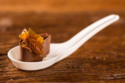 Base of biscuit, mango and passion fruit gel, half bitter chocolate mousse .. Stock Photos