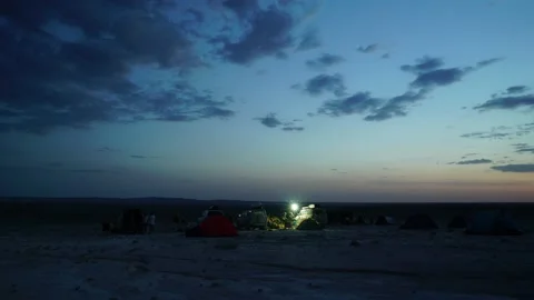 Base camp of tourists on off-road vehicles in the desert in the evening, time Stock Footage 149687301