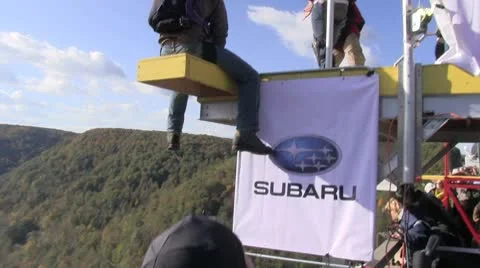 Base jumper gets ready to jump and leaps from platform Stock Footage 8850877