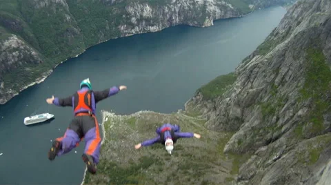 Base jumper jumping of a cliff for an extreme sport Stock Footage 41459212