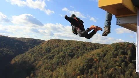 Base jumper jumping off the platform on the New River Gorge Bridge Stock Footage