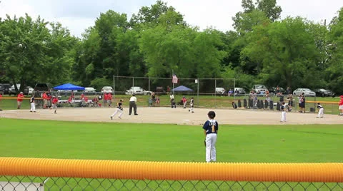 Base runner steals base on catchers error during little league baseball game Stock Footage 25160362