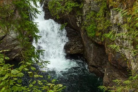 Base of small blue waterfall in summer Stock Photos