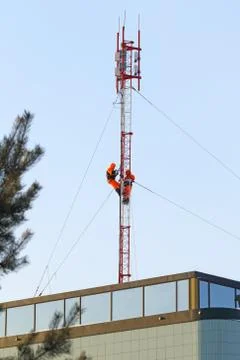 Base station of cellular communication workers and riggers on the mast Fotos de archivo